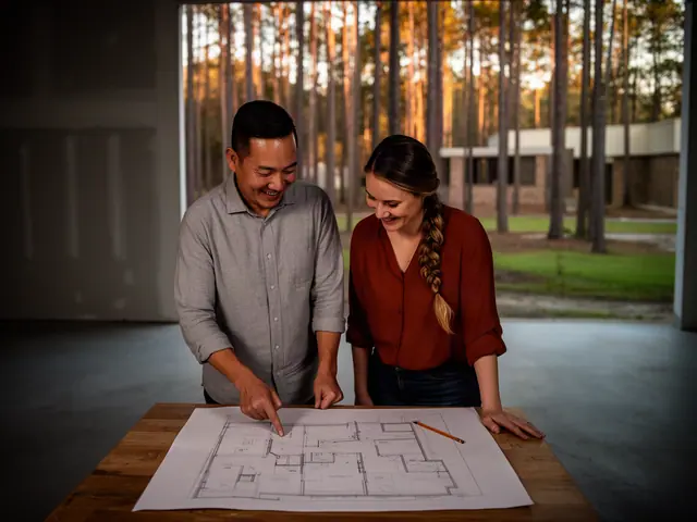 Two business partners looking over a pencil floor sketch in an empty storefront.